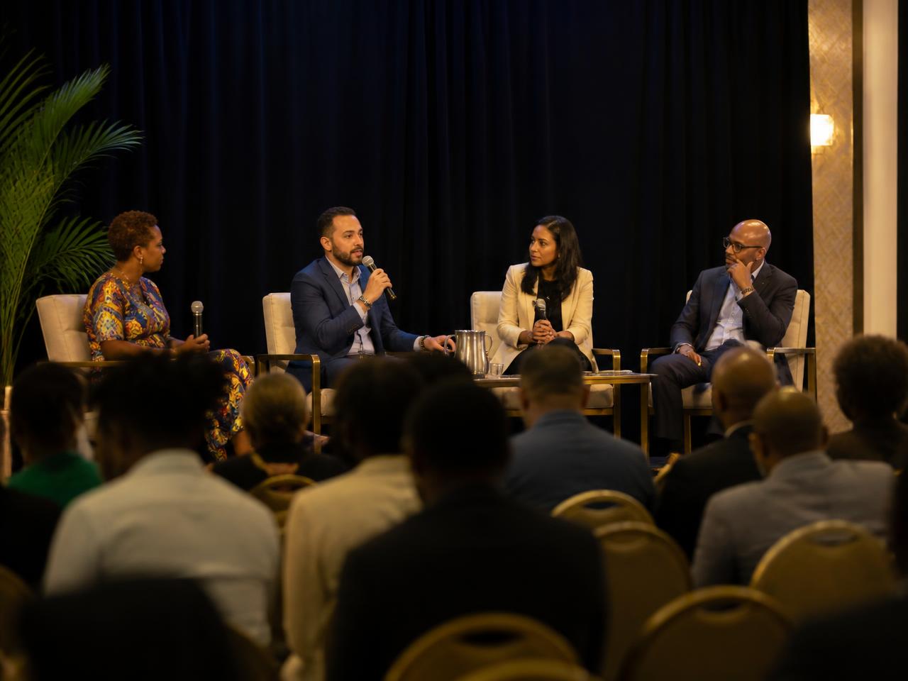 Panellists on stage answering questions from an audience at a Barbados conference